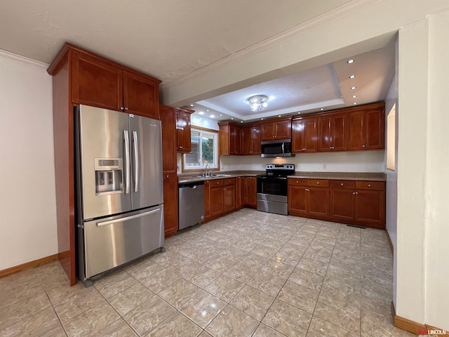 kitchen with crown molding, a sink, a raised ceiling, baseboards, and appliances with stainless steel finishes