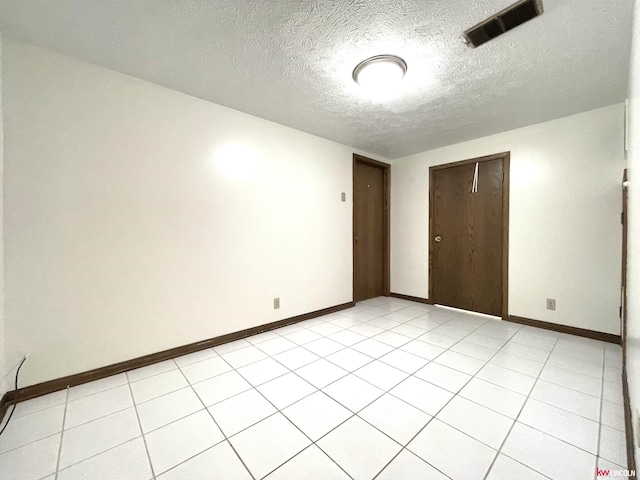 unfurnished bedroom with baseboards, visible vents, a textured ceiling, and a closet