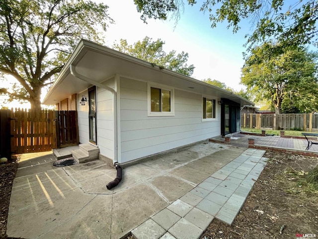 rear view of property with a fenced backyard and a patio area