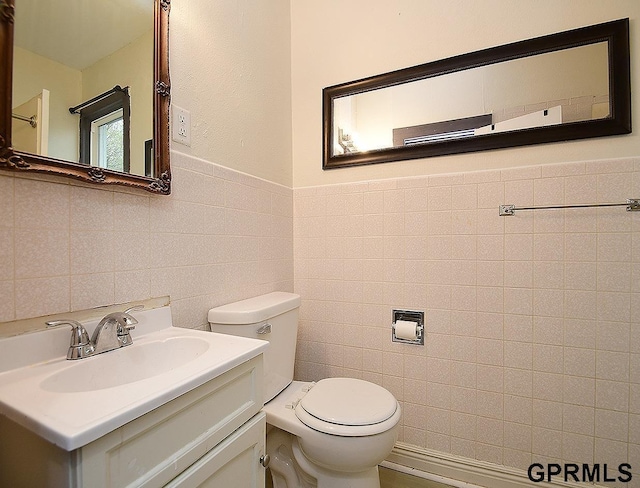 bathroom featuring toilet, tile walls, and vanity