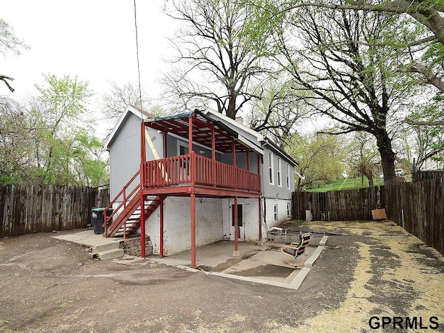 rear view of property featuring a patio, stairway, a fenced backyard, and a deck