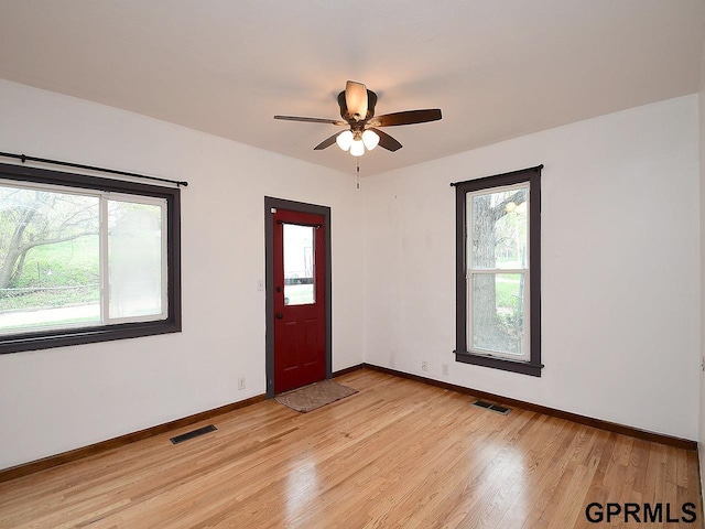 foyer entrance featuring visible vents, baseboards, and light wood-style floors
