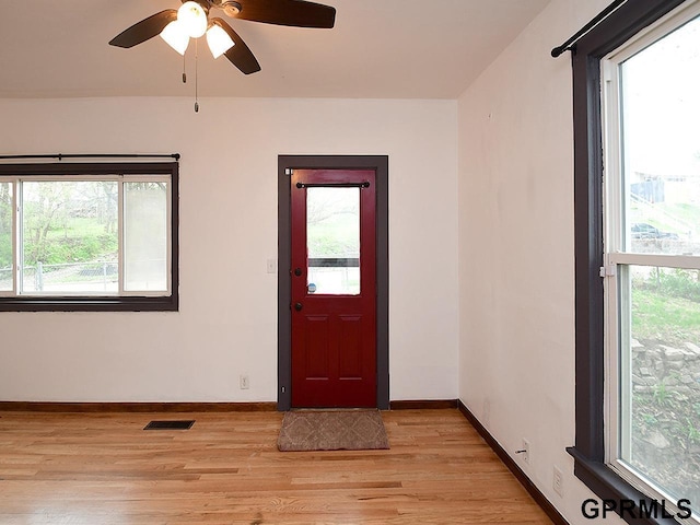 entrance foyer with baseboards, visible vents, a ceiling fan, and light wood-type flooring
