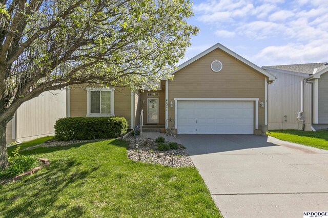 single story home featuring a front lawn, concrete driveway, and an attached garage
