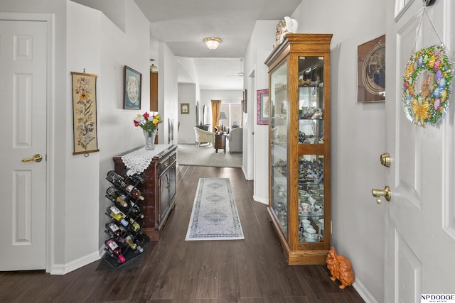 hall with dark wood-style floors and baseboards