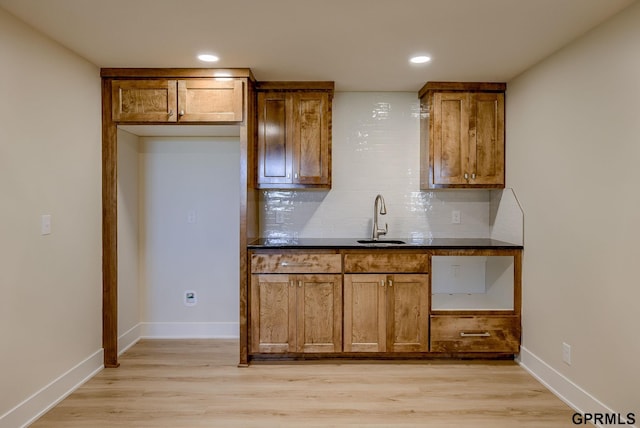20806 Boulder St, Gretna, NE 68028 - kitchen with dark countertops, light wood-style floors, brown cabinetry, and a sink