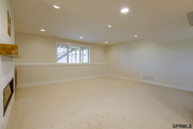 20806 Boulder St, Gretna, NE 68028 - unfurnished living room with light colored carpet, visible vents, baseboards, a glass covered fireplace, and recessed lighting