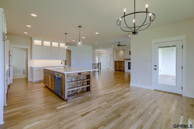 20806 Boulder St, Gretna, NE 68028 - kitchen featuring an island with sink, stainless steel dishwasher, light wood-style flooring, white cabinets, and a sink