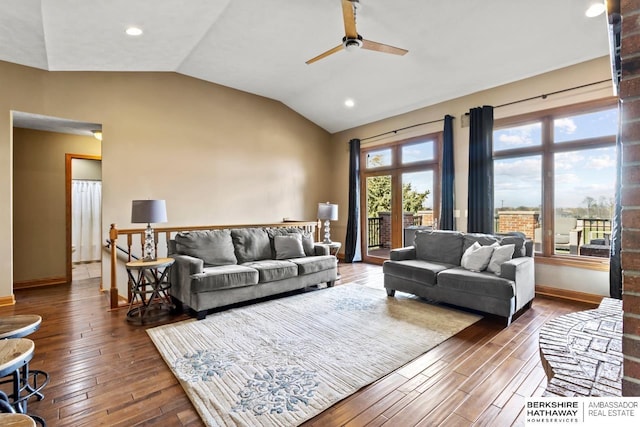living room with hardwood / wood-style flooring, a ceiling fan, vaulted ceiling, and baseboards