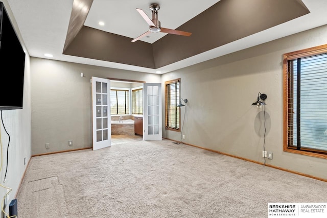 unfurnished room featuring a wealth of natural light, carpet, baseboards, a ceiling fan, and french doors