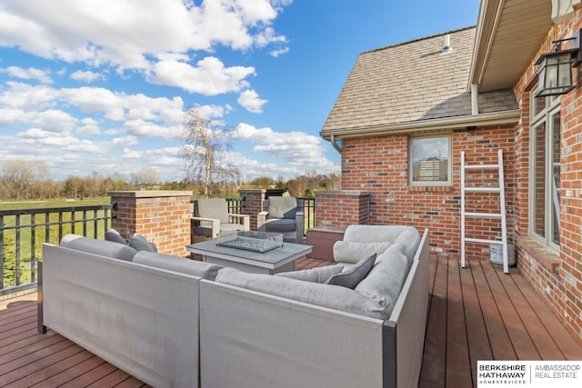 wooden terrace featuring an outdoor living space with a fire pit