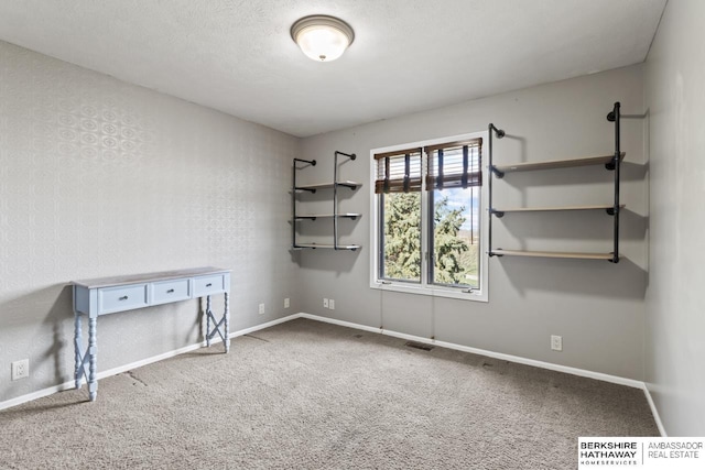 unfurnished room featuring baseboards, visible vents, and carpet flooring
