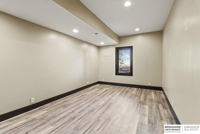 empty room featuring baseboards, light wood-type flooring, and recessed lighting
