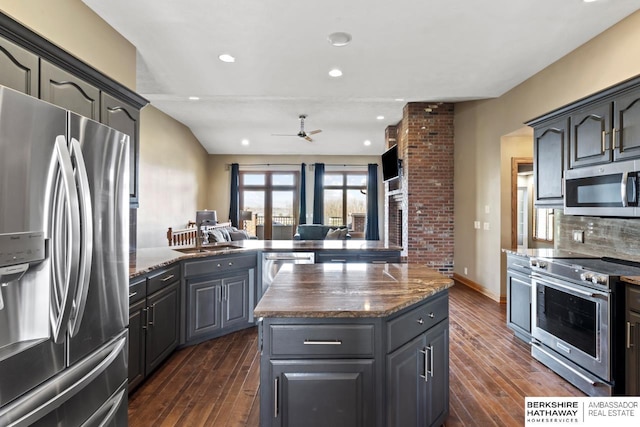 kitchen featuring a sink, ceiling fan, a peninsula, a kitchen island, and appliances with stainless steel finishes