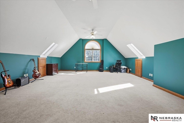 bonus room featuring lofted ceiling with skylight, a ceiling fan, carpet flooring, and baseboards
