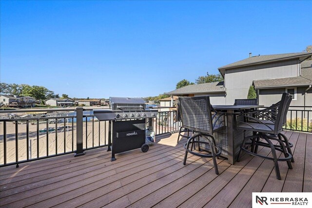 deck featuring a residential view, outdoor dining area, and grilling area