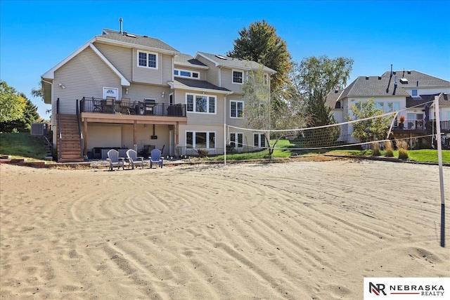 rear view of property with volleyball court and central AC unit