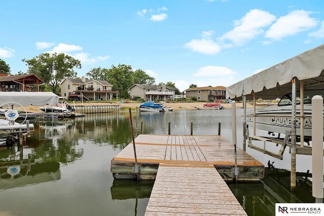 view of dock with a residential view, a water view, and boat lift