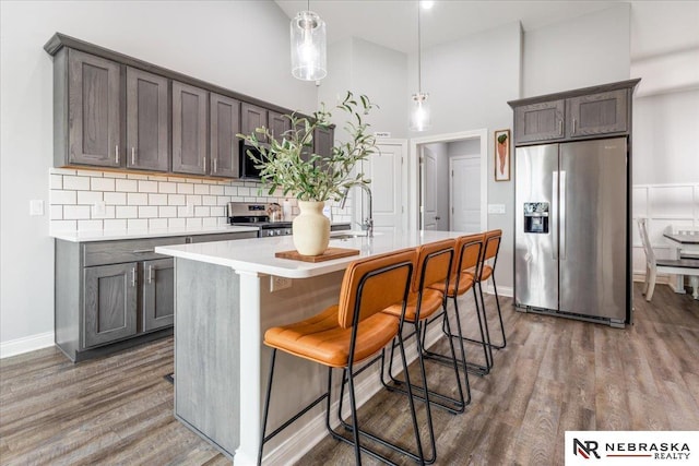 708 Sunset Blvd, Palmyra, NE 68418 - kitchen with stainless steel appliances, wood finished floors, a sink, light countertops, and a high ceiling