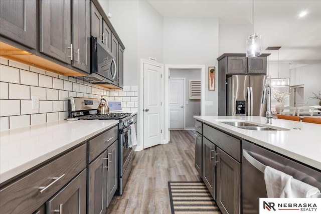 708 Sunset Blvd, Palmyra, NE 68418 - kitchen featuring stainless steel appliances, light countertops, wood finished floors, and backsplash