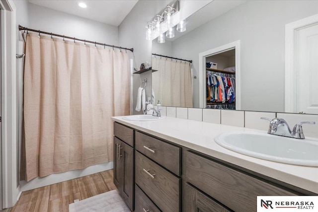 708 Sunset Blvd, Palmyra, NE 68418 - full bathroom with wood finished floors, double vanity, a spacious closet, shower / tub combo, and recessed lighting