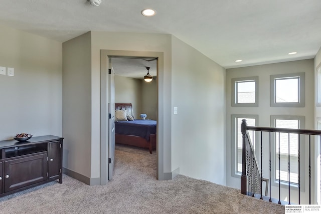 corridor with light colored carpet, recessed lighting, baseboards, and an upstairs landing