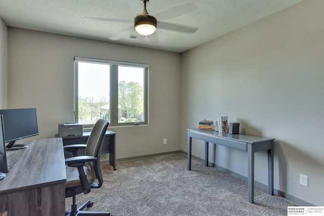 office space with visible vents, carpet, ceiling fan, and baseboards
