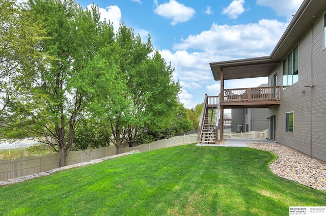 view of yard with stairs, a fenced backyard, and a wooden deck