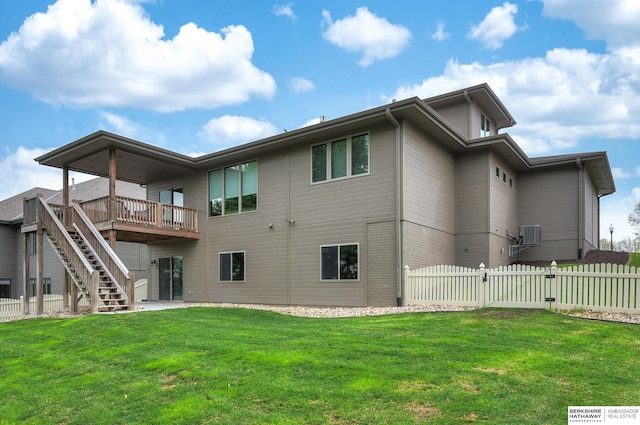 back of property with a lawn, a wooden deck, a gate, fence, and stairs