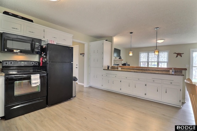 kitchen with light wood finished floors, black appliances, a peninsula, a textured ceiling, and white cabinets