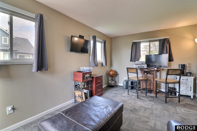 carpeted office space with a healthy amount of sunlight, visible vents, and baseboards