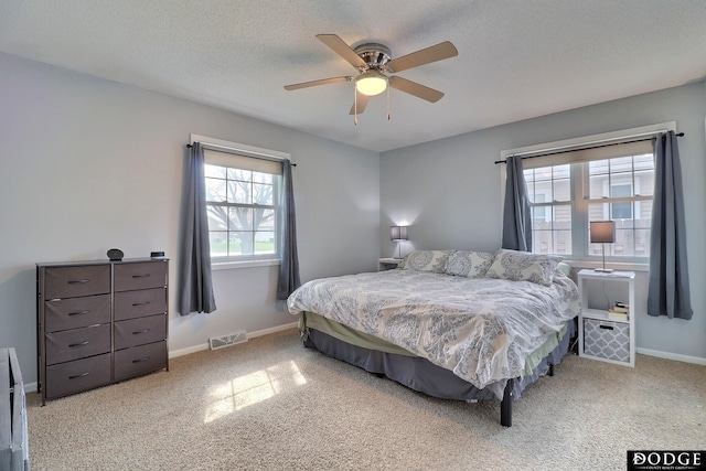 bedroom with visible vents, a ceiling fan, carpet flooring, and baseboards