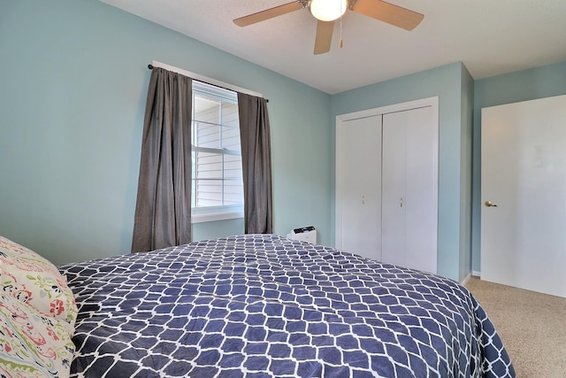 carpeted bedroom featuring ceiling fan and a closet