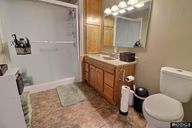 bathroom featuring baseboards, a stall shower, toilet, and vanity