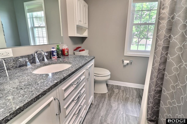 full bath with vanity, toilet, and baseboards