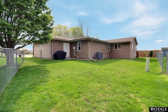 back of property with central AC, a fenced backyard, and a yard