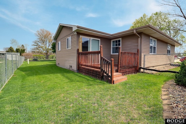 rear view of property featuring fence and a lawn