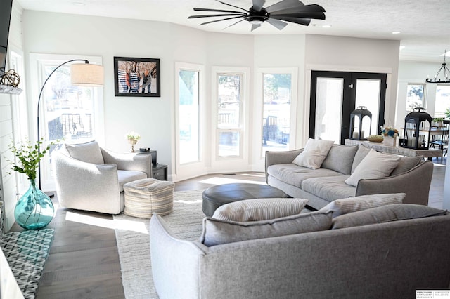 living room featuring recessed lighting, wood finished floors, ceiling fan with notable chandelier, and french doors