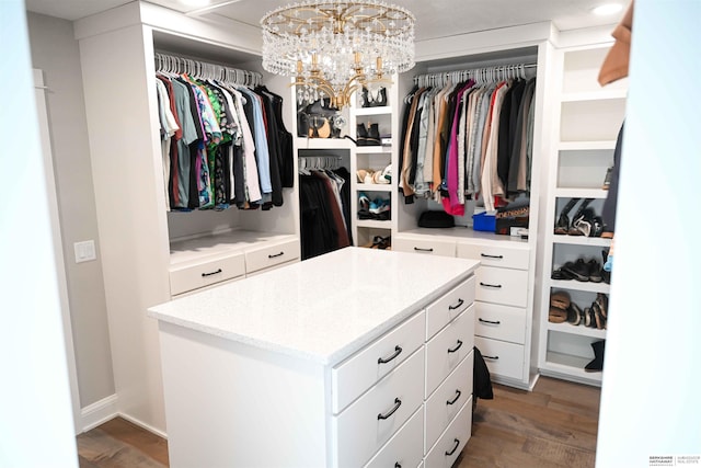 walk in closet featuring light wood finished floors and an inviting chandelier