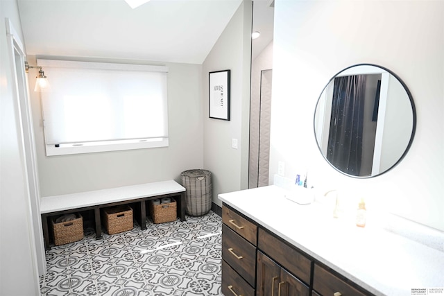 bathroom featuring lofted ceiling and vanity