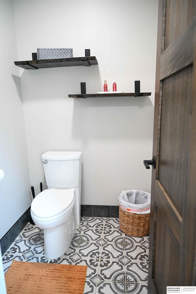 half bath featuring tile patterned floors and toilet