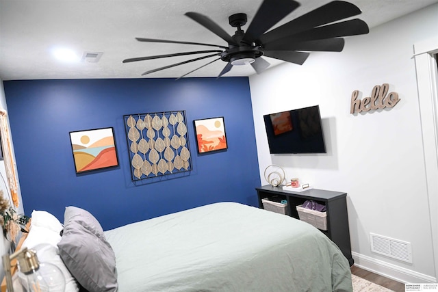 bedroom with wood finished floors, visible vents, ceiling fan, and baseboards