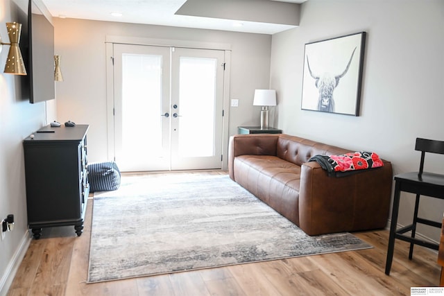 living room with wood finished floors, french doors, and baseboards
