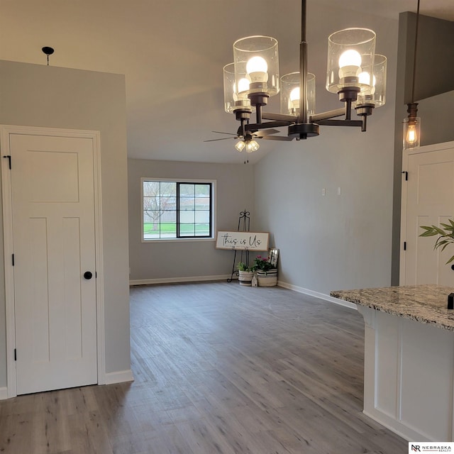 129 E 5th St, Valparaiso, NE 68065 - dining room with a chandelier, a ceiling fan, wood finished floors, and baseboards