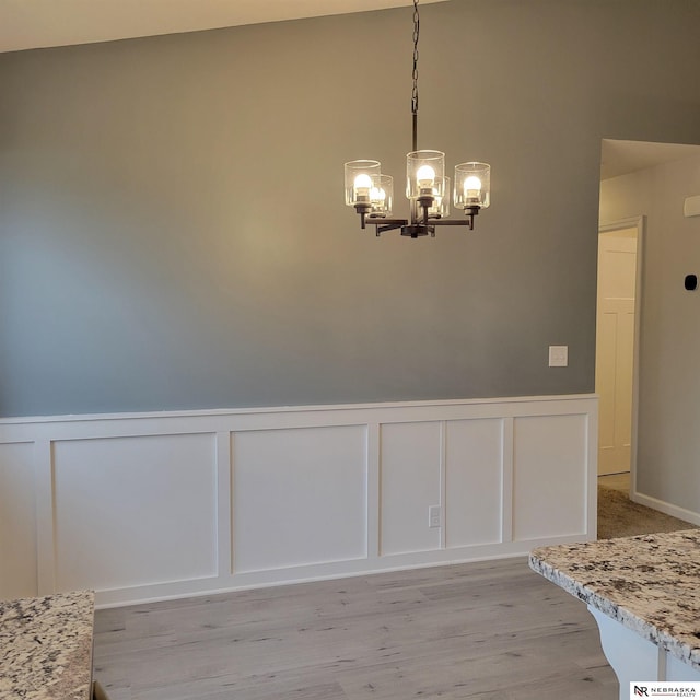 129 E 5th St, Valparaiso, NE 68065 - unfurnished dining area featuring a decorative wall, a chandelier, a wainscoted wall, and light wood finished floors