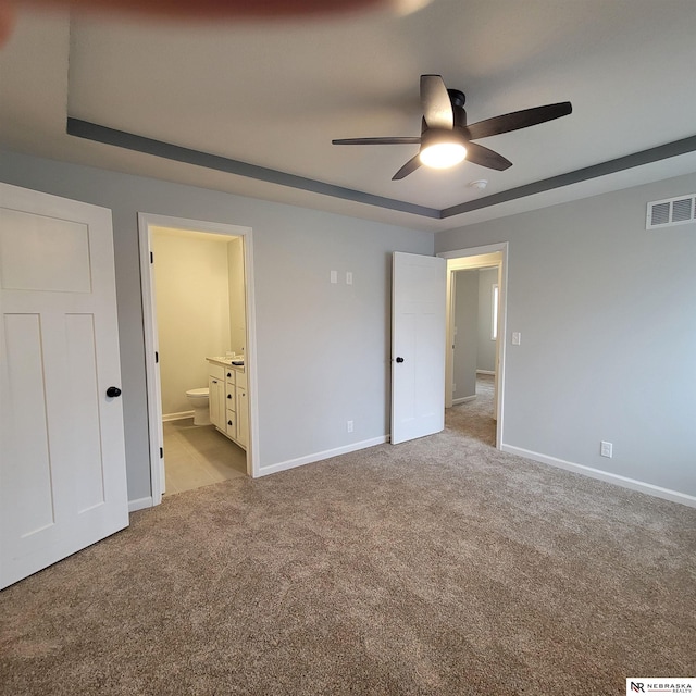 129 E 5th St, Valparaiso, NE 68065 - unfurnished bedroom with light carpet, baseboards, connected bathroom, and ceiling fan