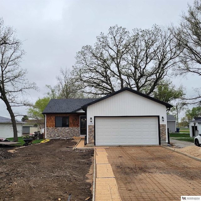 129 E 5th St, Valparaiso, NE 68065 - view of front of home with stone siding, a garage, and decorative driveway