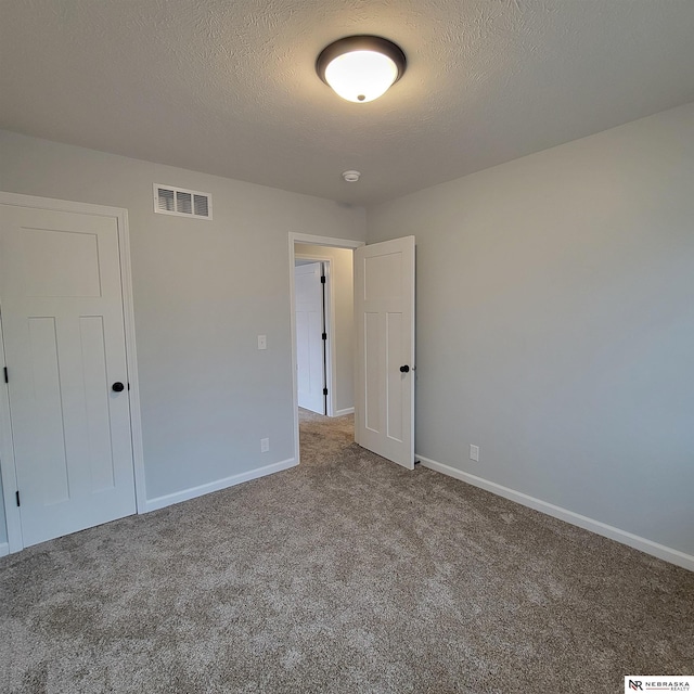 129 E 5th St, Valparaiso, NE 68065 - unfurnished bedroom with carpet flooring, baseboards, and a textured ceiling