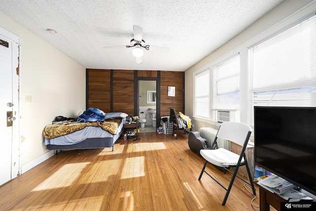 2406 J St, Lincoln, NE 68510 - bedroom with wood walls, wood finished floors, ceiling fan, and a textured ceiling