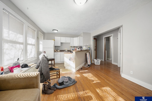 2406 J St, Lincoln, NE 68510 - living room featuring baseboards, a textured ceiling, and light wood-style flooring
